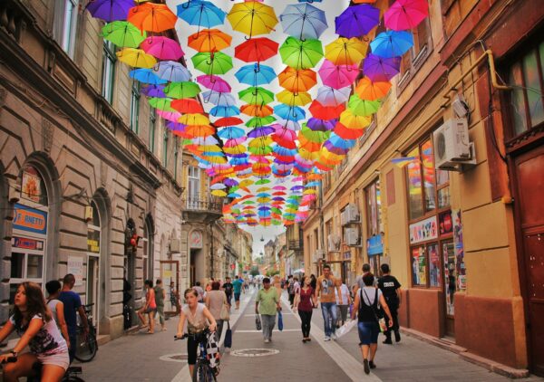 assorted-color umbrella hanged above pathway near houses